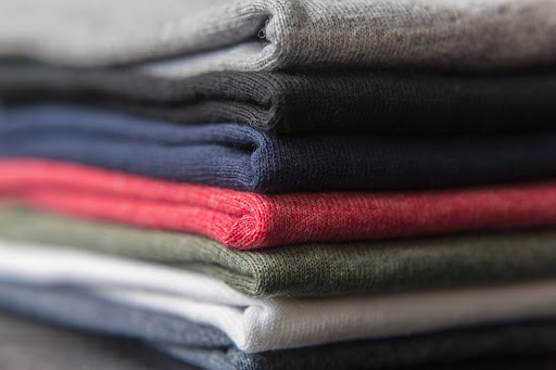 A pile of multicolored folded t-shirts