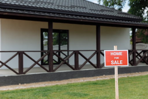 A simple “for sale” sign is shown outside of a home