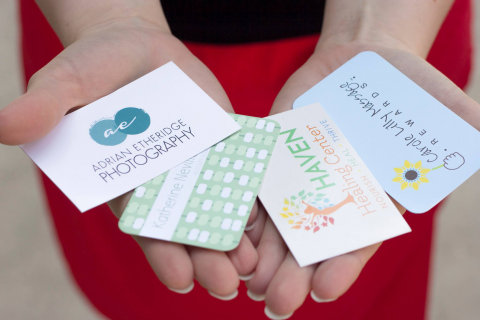 Woman holding a variety of business cards.