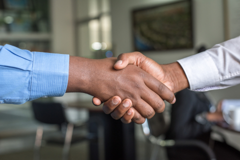 Close up of two men shaking hands.