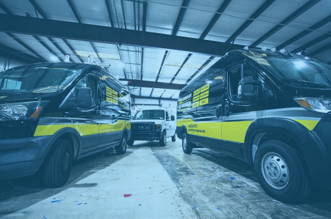 Two cargo vans with graphics wraps.