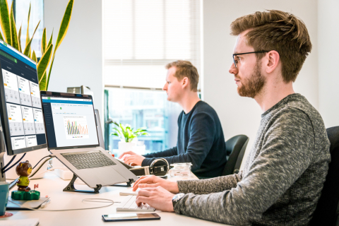 Two men working at computers in an office.